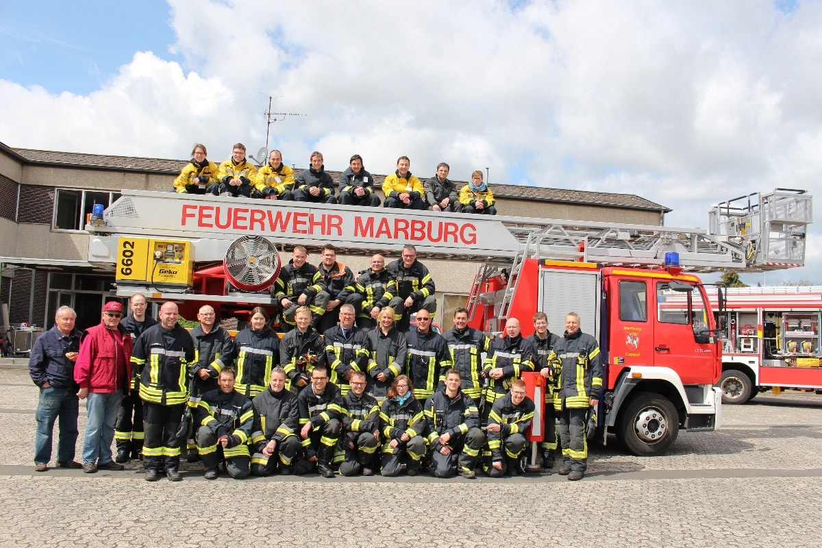 Gruppenbild - Teilnehmer/-innen auf dem Leiterpark sitzend Gruppenbild - Teilnehmer/-innen auf dem Leiterpark sitzend